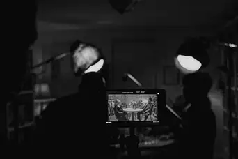 film set interior, a camera monitor showing the scene.