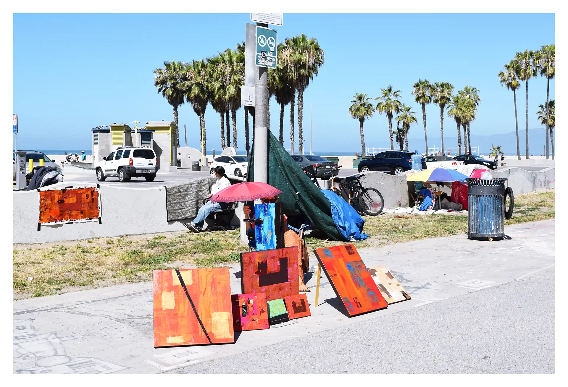 Los Angeles, colourful paintings resting against a pillar, sunny