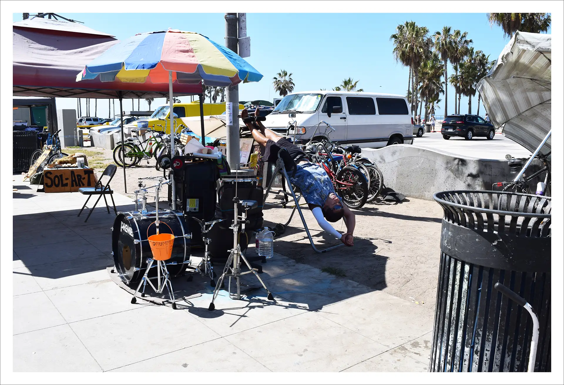 Los Angeles, man by a set of drums under a marquee, sunny