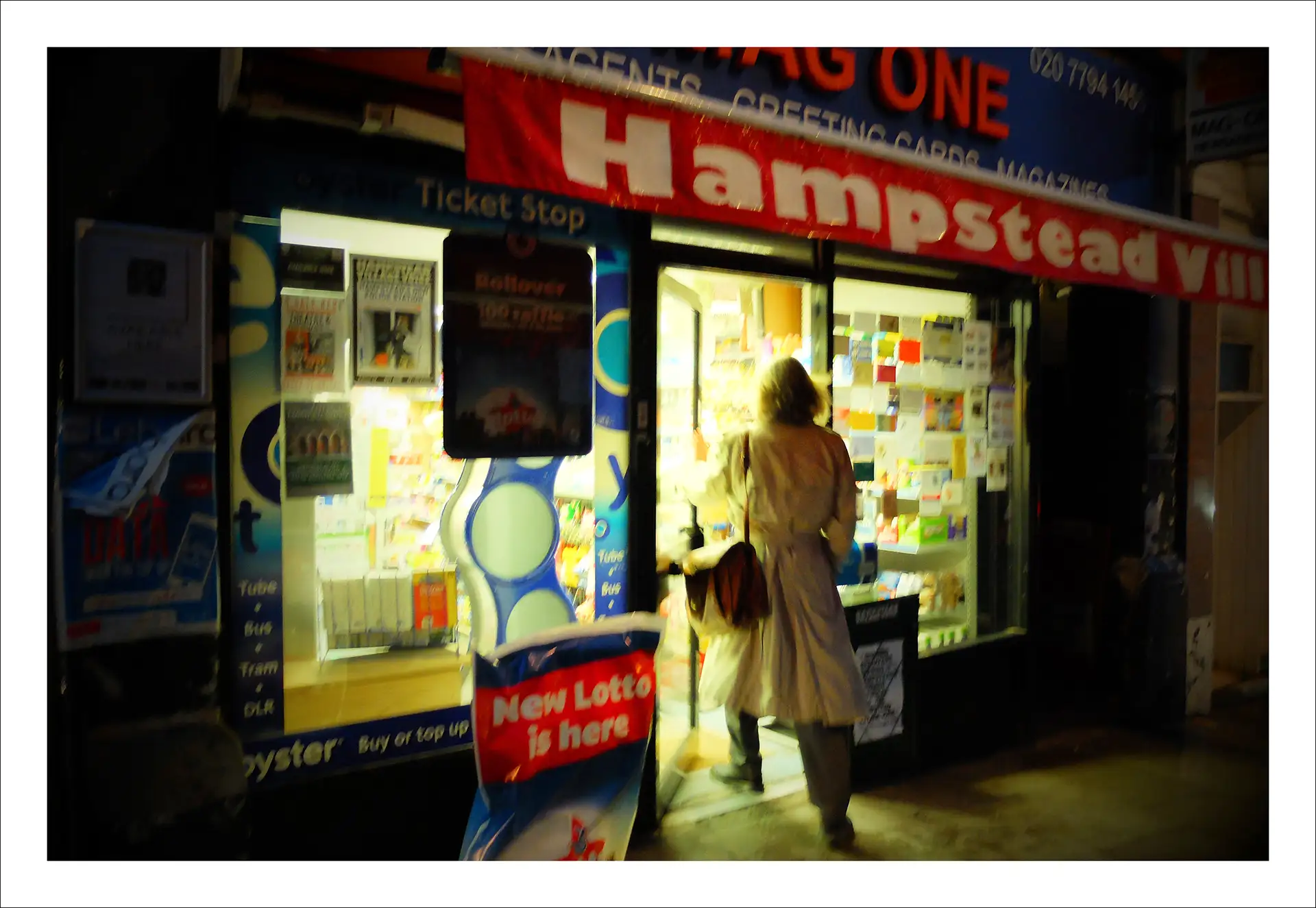 London, woman walking into a shop at night