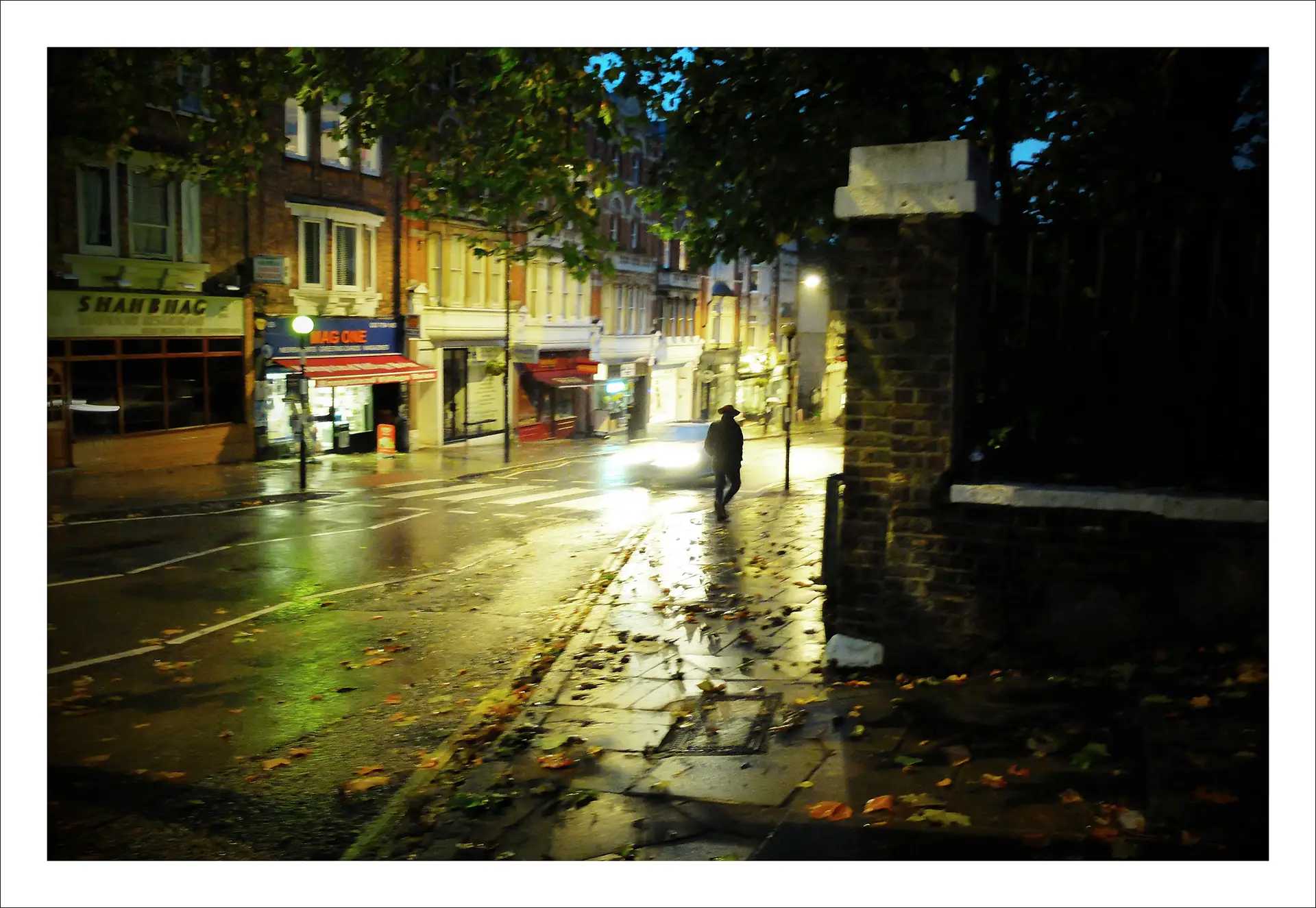 London, man walking along a pavement at night