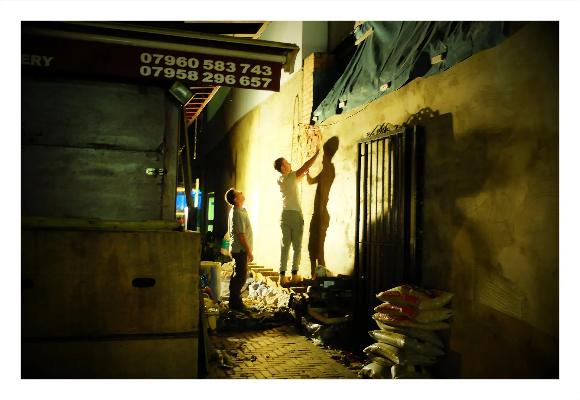 London, two men graffitting at night