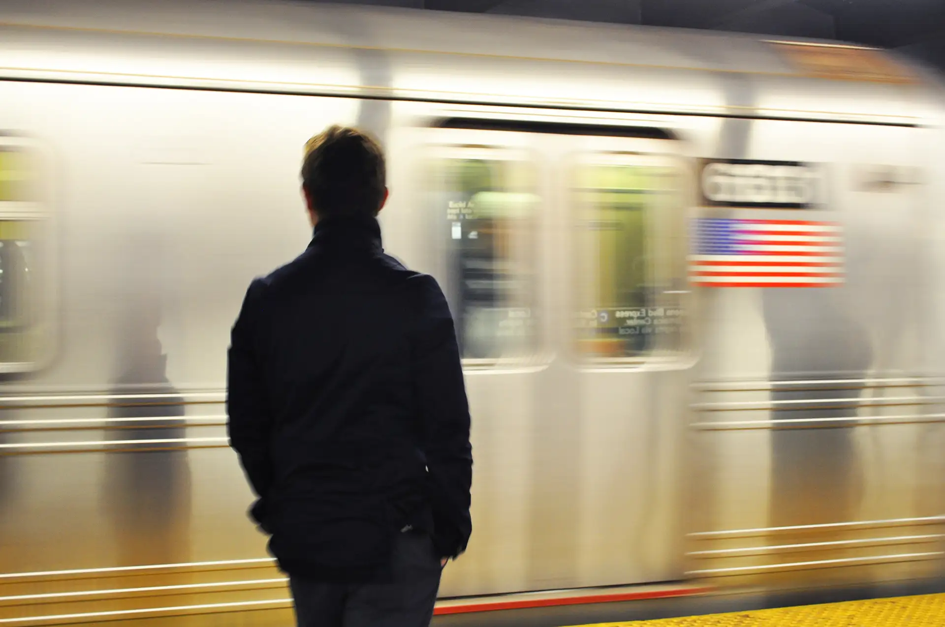 New York, man standing in front of fast moving train